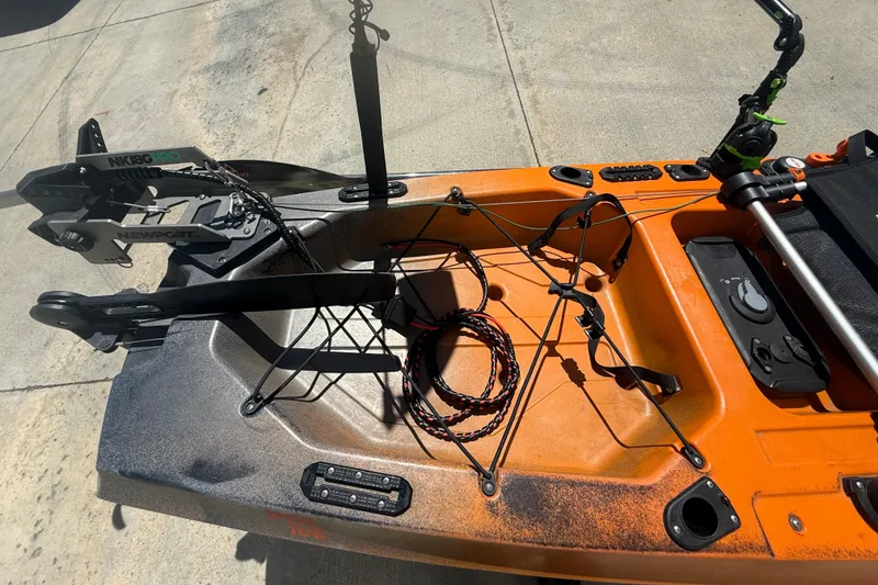 Slide: The Image of Orange OldTown Sportsman PDL 106 kayak with pedal drive system, 2023 model, on concrete surface. - 7