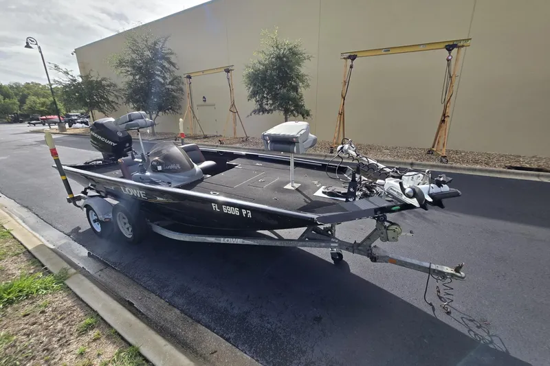Slide: The Image of 2014 Lowe Stinger 18 HP boat on trailer, parked outdoors. - 1
