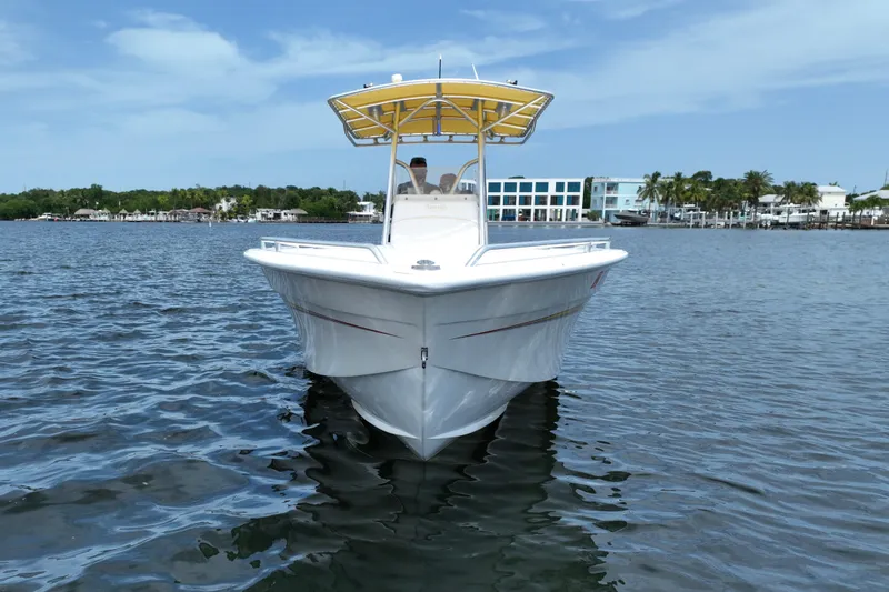 Slide: The Image of 2004 Carrera Boats 27 CC Open on calm water, featuring a yellow canopy and sleek design. - 9