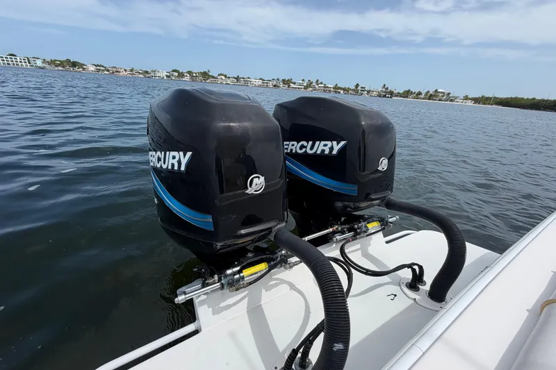 Slide: The Image of Twin Mercury outboard engines on a 2004 Carrera Boats 27 CC Open, cruising on calm waters. - 22