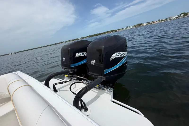 Slide: The Image of Twin Mercury outboard engines on a 2004 Carrera Boats 27 CC Open, cruising on calm waters. - 32