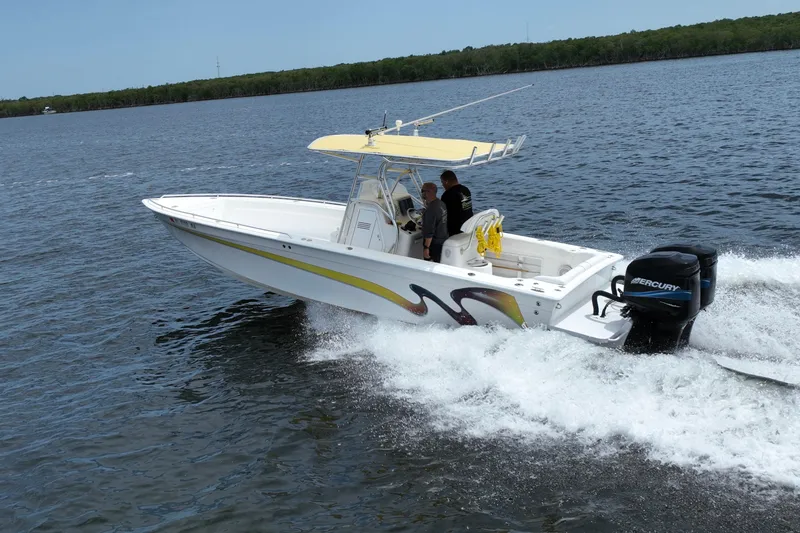 Slide: The Image of 2004 Carrera Boats 27 CC Open cruising on water with vibrant graphics and Mercury engines. - 7