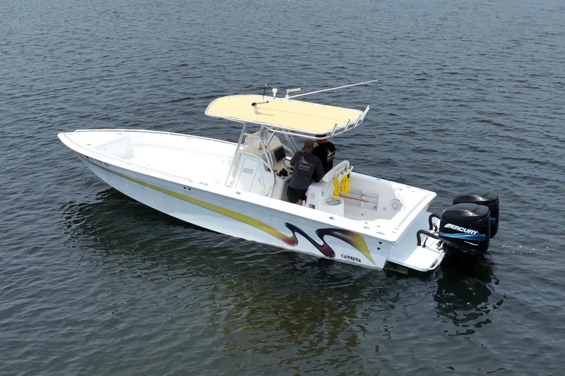 Slide: The Image of 2004 Carrera Boats 27 CC Open on water, featuring dual Mercury engines and a yellow canopy. - 5