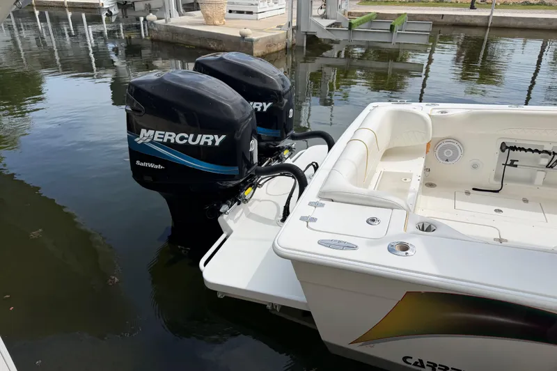 Slide: The Image of 2004 Carrera Boats 27 CC Open with twin Mercury outboards docked in calm waters. - 33