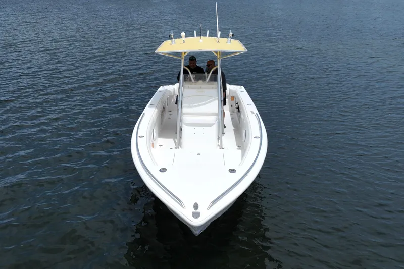 Slide: The Image of 2004 Carrera Boats 27 CC Open on calm water, featuring a yellow canopy. - 8