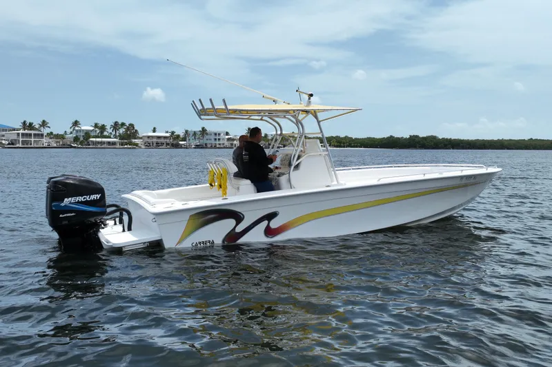 Slide: The Image of 2004 Carrera Boats 27 CC Open on water, featuring Mercury outboard engine, clear sky background. - 3