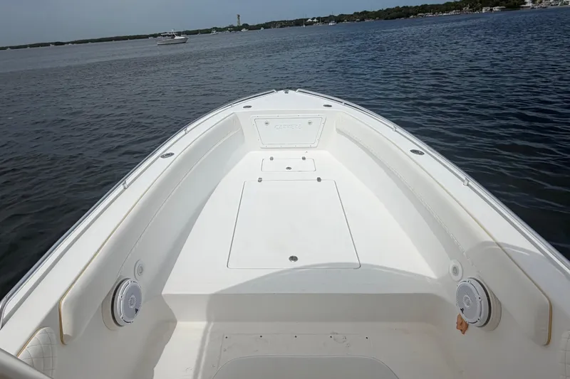 Slide: The Image of 2004 Carrera Boats 27 CC Open on calm water, showcasing spacious deck and sleek design. - 10