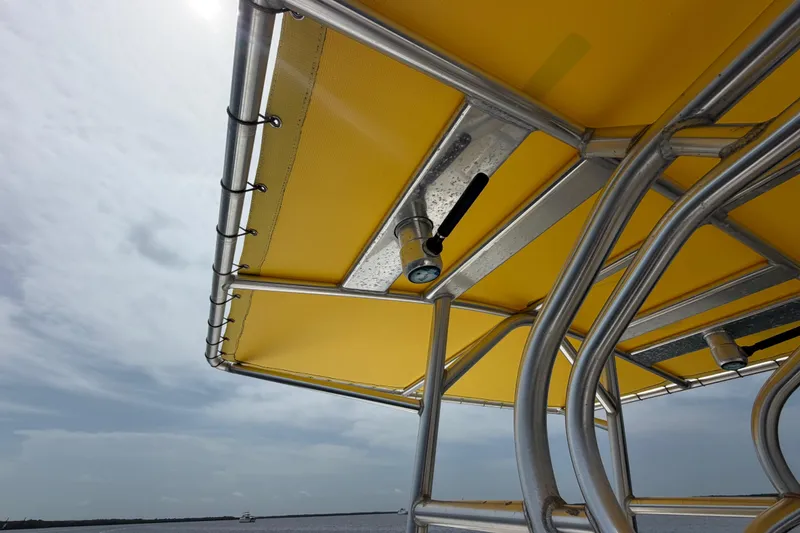 Slide: The Image of Yellow canopy on 2004 Carrera Boats 27 CC Open, featuring metal framework against a cloudy sky. - 18