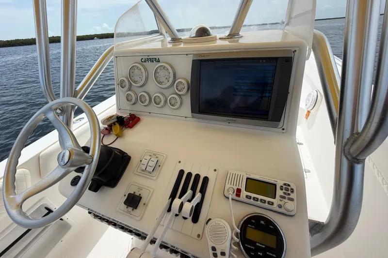 Slide: The Image of 2004 Carrera Boats 27 CC Open dashboard with steering wheel, gauges, and navigation equipment. - 24