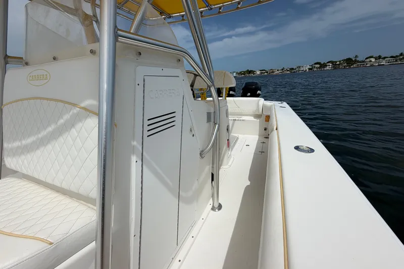 Slide: The Image of 2004 Carrera Boats 27 CC Open on water, featuring white seating and sleek design. - 19