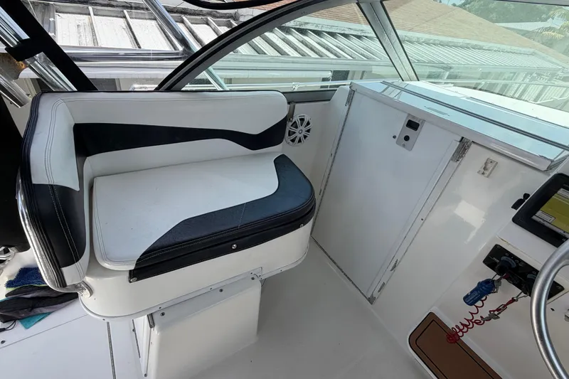 Slide: The Image of Interior of a 2001 Stamas 270 Express boat, featuring a cushioned seat and control panel. - 33
