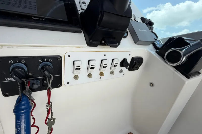 Slide: The Image of Control panel of a 2001 Stamas 270 Express boat with switches and keys. - 27