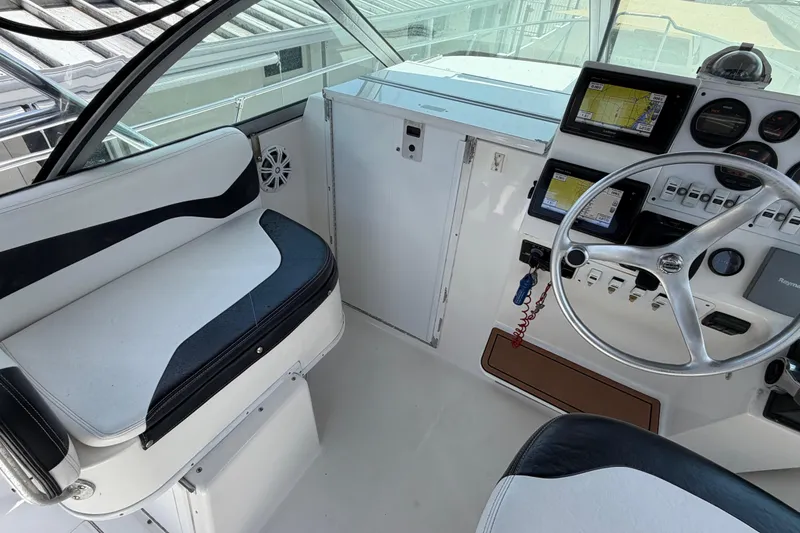 Slide: The Image of 2001 Stamas 270 Express boat cockpit with steering wheel and navigation equipment. - 32