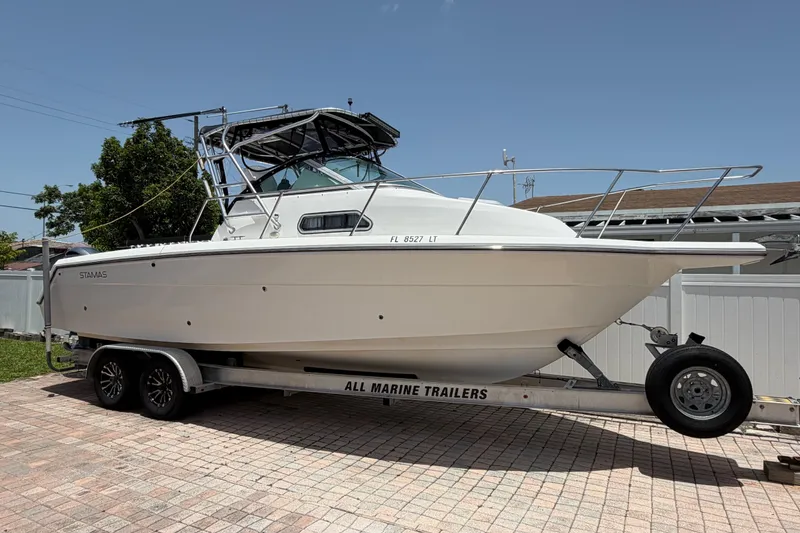 Slide: The Image of 2001 Stamas 270 Express boat on trailer, parked on brick driveway. - 2