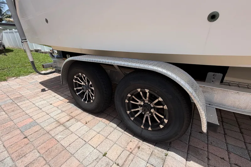 Slide: The Image of Trailer wheels of a 2001 Stamas 270 Express boat on a brick driveway. - 11