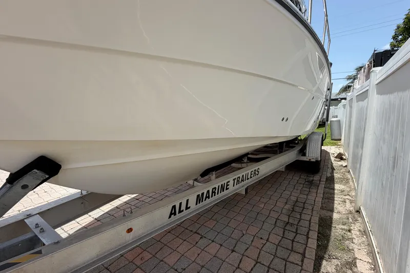 Slide: The Image of 2001 Stamas 270 Express boat on trailer, side view, parked on brick driveway. - 10
