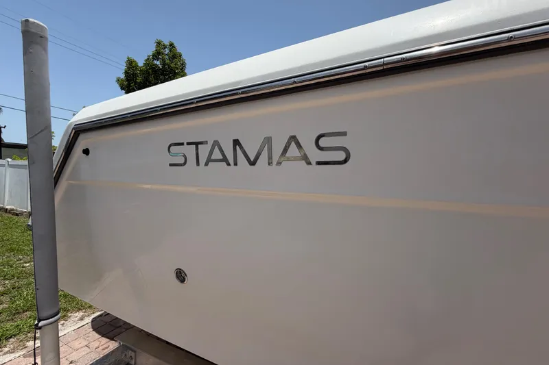 Slide: The Image of 2001 Stamas 270 Express boat side view with logo under clear blue sky. - 9