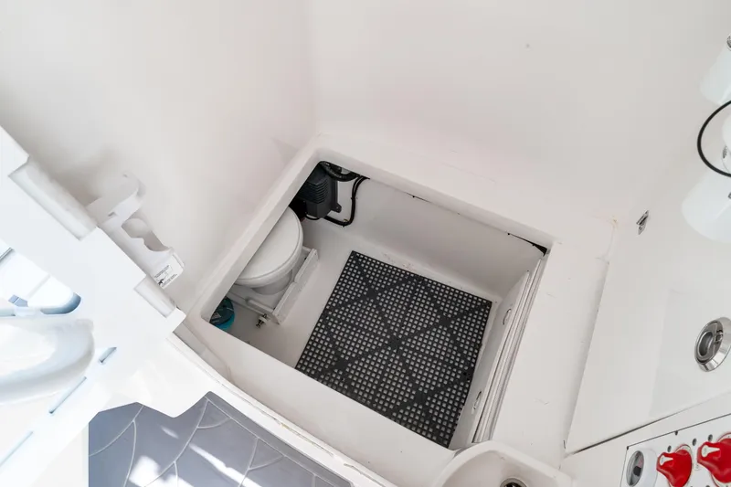 Slide: The Image of 2022 Contender 32 ST boat interior with compact marine toilet and storage area. - 27