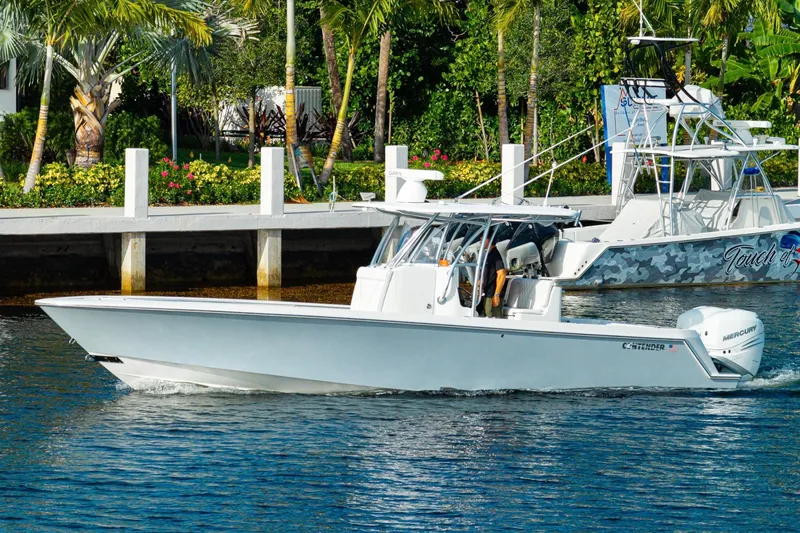 Slide: The Image of 2022 Contender 32 ST boat cruising on a sunny day near a tropical dock. - 14