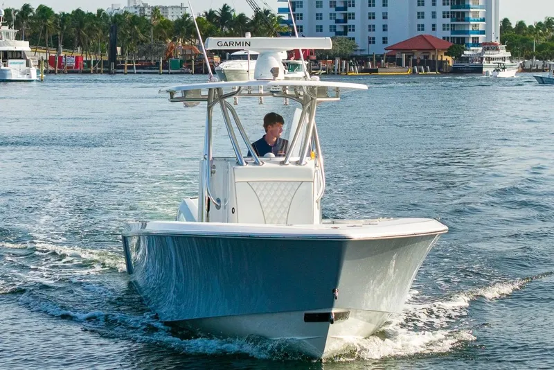Slide: The Image of 2022 Contender 32 ST boat cruising on water near a marina. - 16