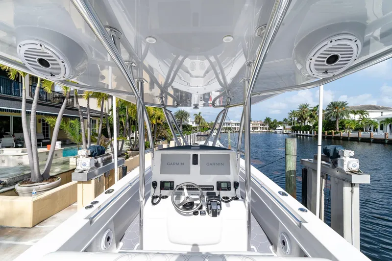 Slide: The Image of 2022 Contender 32 ST boat cockpit with Garmin navigation, docked by waterfront homes. - 19
