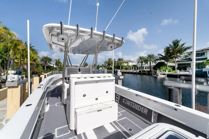 Slide: The Image of 2022 Contender 32 ST boat docked by a scenic waterfront with palm trees. - 23