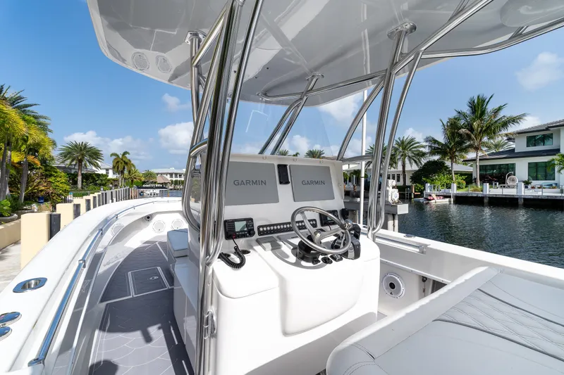 Slide: The Image of 2022 Contender 32 ST boat with Garmin navigation, docked by waterfront homes. - 24