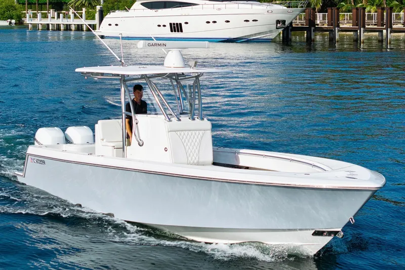 Slide: The Image of 2022 Contender 32 ST boat cruising on water with luxury yacht in background. - 4