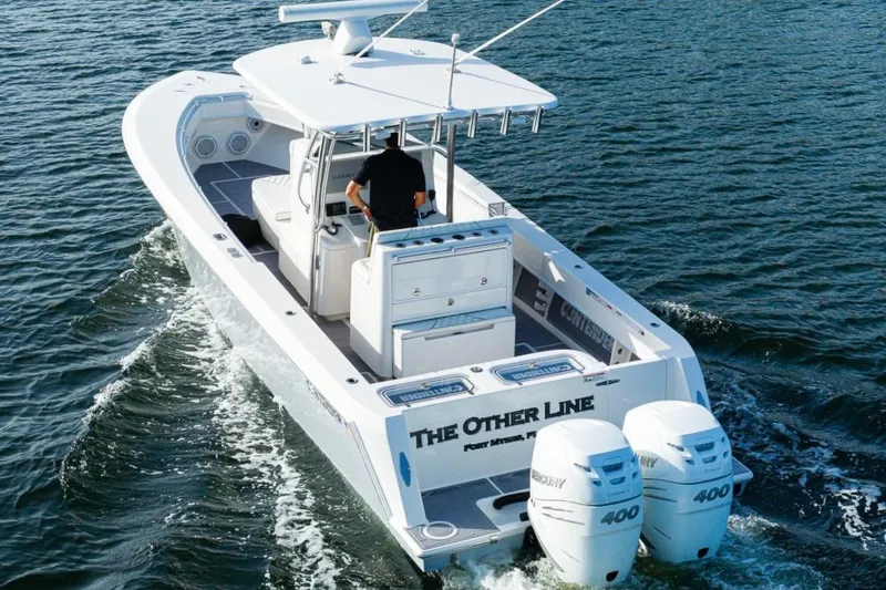 Slide: The Image of 2022 Contender 32 ST boat cruising on water with twin Mercury 400 engines. - 6