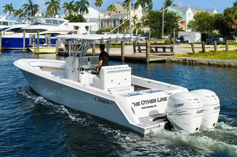 Slide: The Image of 2022 Contender 32 ST boat with twin Mercury 400 engines cruising in a marina. - 10
