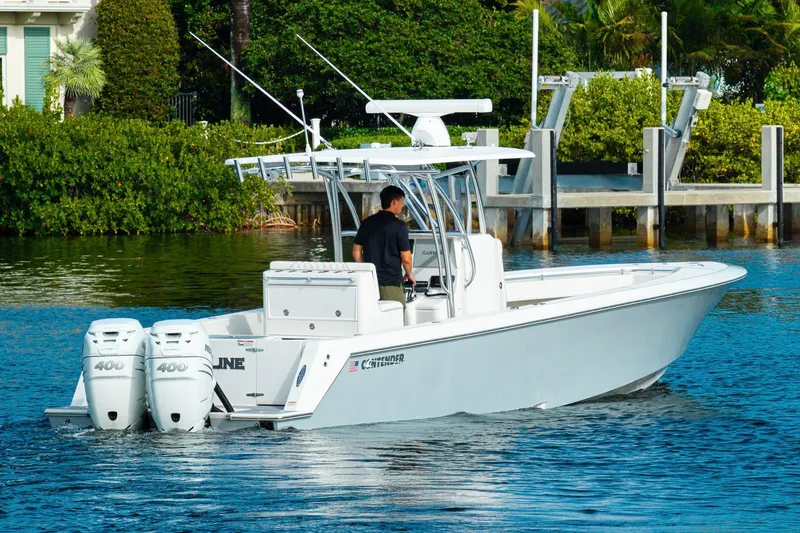 Slide: The Image of 2022 Contender 32 ST boat with dual engines cruising on a calm waterway. - 7