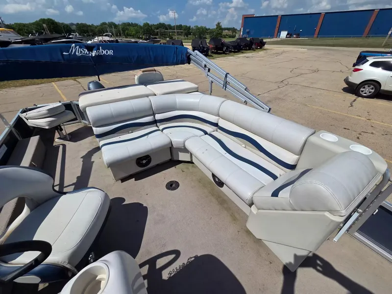 Slide: The Image of A 2010 Misty Harbor 2085 CF pontoon boat with white and blue seating, parked in a lot. - 12