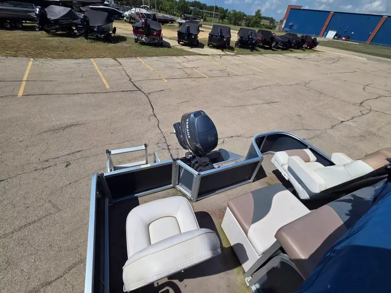 Slide: The Image of A 2010 Misty Harbor 2085 CF pontoon boat with outboard motor, parked boats in the background. - 11