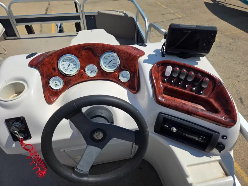 Slide: The Image of The image shows the helm of a 2010 Misty Harbor 2085 CF boat with wood trim and instruments. - 9