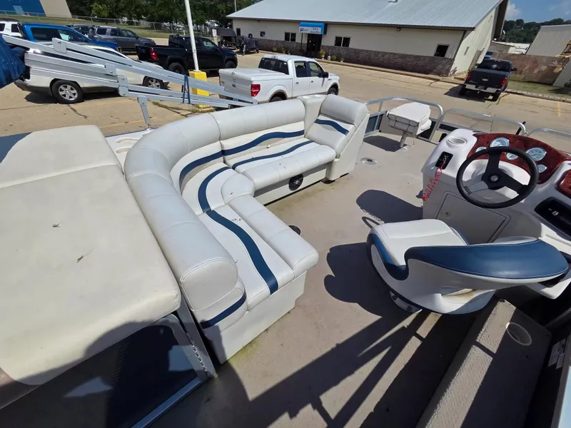 Slide: The Image of The image shows the interior of a 2010 Misty Harbor 2085 CF pontoon boat with white and blue seating. - 8