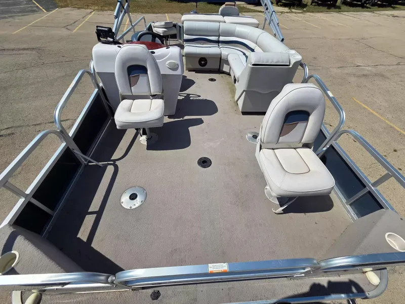 Slide: The Image of The image shows a 2010 Misty Harbor 2085 CF pontoon boat with gray seating and an open deck. - 2