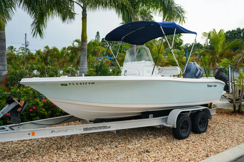 Slide: The Image of 2011 Tidewater 196 CC Adventure boat on trailer, surrounded by palm trees. - 3