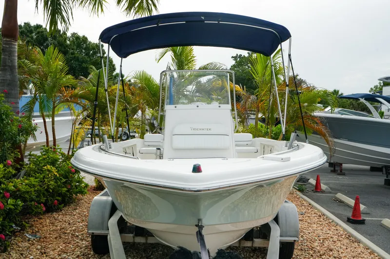 Slide: The Image of 2011 Tidewater 196 CC Adventure boat with canopy, parked among tropical plants. - 4
