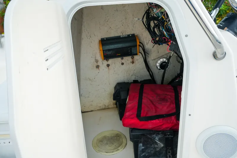 Slide: The Image of Interior view of a 2011 Tidewater 196 CC Adventure boat's storage compartment with wiring and equipment. - 13