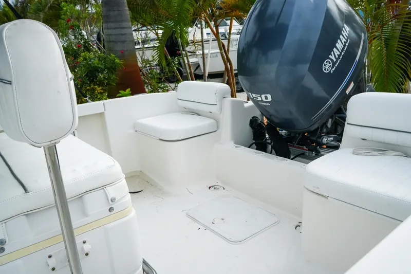 Slide: The Image of 2011 Tidewater 196 CC Adventure boat interior with Yamaha 150 engine, white seating, and lush greenery. - 17