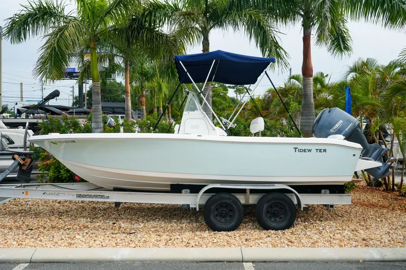 The Image of 2011 Tidewater 196 CC Adventure boat on trailer, surrounded by palm trees. - 1
