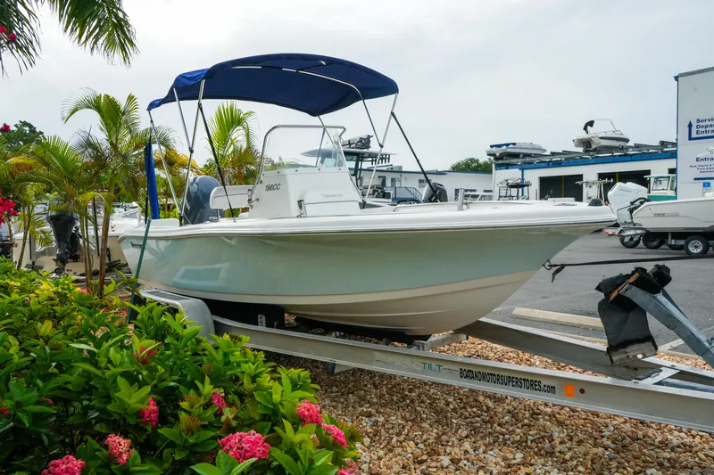 Slide: The Image of 2011 Tidewater 196 CC Adventure boat on trailer, surrounded by tropical plants. - 5