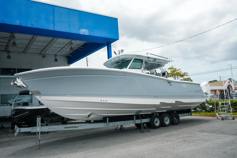 The Image of 2025 Blackfin 400 CC boat on trailer at dealership, under blue canopy. - 1