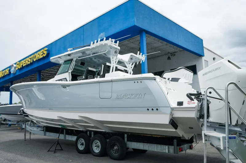Slide: The Image of 2025 Blackfin 400 CC boat on trailer at dealership, featuring Mercury engines. - 3