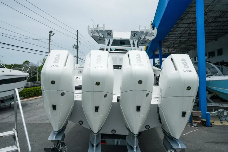 Slide: The Image of 2025 Blackfin 400 CC boat with four powerful outboard engines, displayed at a marina. - 5