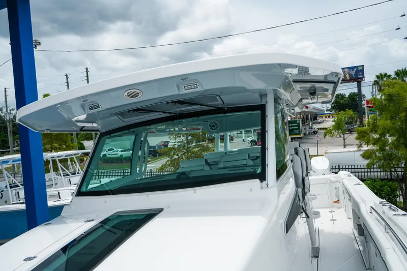 Slide: The Image of 2025 Blackfin 400 CC boat with sleek design, docked under cloudy skies. - 24
