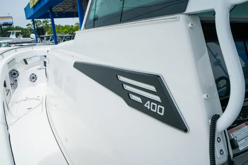 Slide: The Image of 2025 Blackfin 400 CC boat, sleek design with modern detailing, docked at a marina. - 19