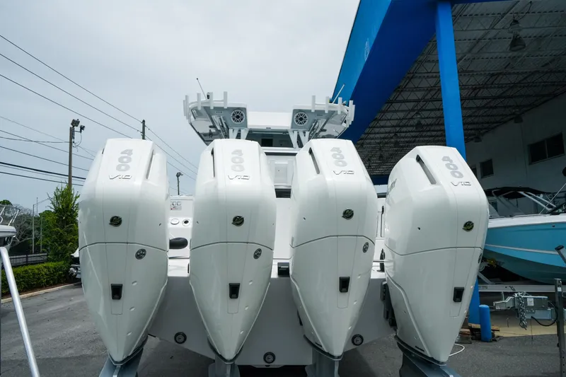 Slide: The Image of 2025 Blackfin 400 CC boat with four powerful outboard engines at a marina. - 6