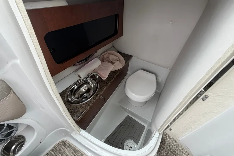 Slide: The Image of 2018 Crownline 285 SS boat bathroom with sink, toilet, and countertop. - 15