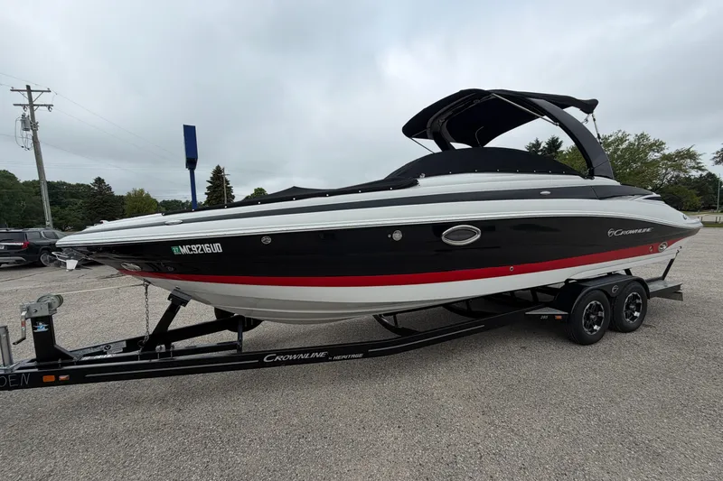 The Image of 2018 Crownline 285 SS boat on trailer, black and red design, parked outdoors. - 0